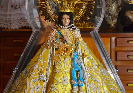 La indumentaria de la Virgen de Zapopan destaca por sus tonos dorados. La imagen es de forma triangular, de capa larga y bordada sobre  telas finas.