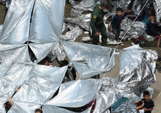 El Economista te presenta imágenes del campamento improvisado en McAllen, Texas de la Patrulla Fronteriza de los Estados Unidos donde adultos y niños duermen en el suelo y arreglan techos improvisados con mantas reflejantes para protegerse del sol. La temperatura del suelo es aproximadamente de 32 grados Celsius alrededor del mediodía. El gobierno de los Estados Unidos ha dicho que está luchando con una oleada de solicitantes que viajan a través de México y piden asilo.