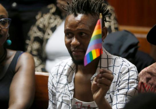 Un activista LGBT sostiene la bandera del arco iris durante una audiencia en el tribunal superior de Milimani en Nairobi en Nairobi, Kenia.