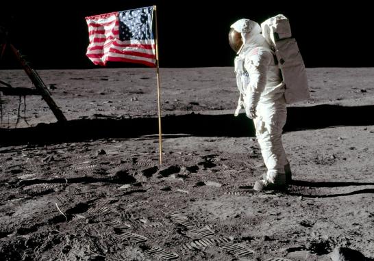 Imagen del primer hombre en pisar la luna. El astronauta Buzz Aldrin posa para una fotografía con la bandera de los Estados Unidos clavada en la Luna el 20 de julio de 1969, durante la actividad extravehicular en la misión del Apolo 11. El módulo lunar está a la izquierda y las huellas de los astronautas son visibles en el suelo.