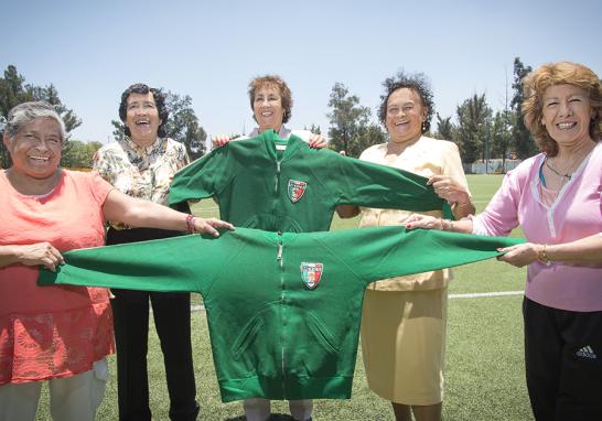 Yolanda Ramírez, Irma Chávez, Alicia Vargas, Elvira Aracén y Lourdes de la Rosa sostienen esas chamarras de paño que tanto calor les provocaba. Minutos antes de abordar el avión a Italia, rumbo al primer mundial, les llegó la donación de estas chaquetas. Foto: Lizeth Arauz