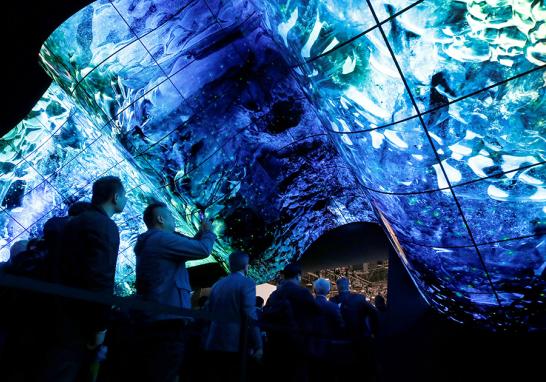 Los asistentes ingresan a un stand de LG Electronics debajo de una pantalla de paneles OLED flexibles durante el CES 2020 en Las Vegas. FOTO: REUTERS