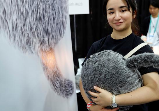 Saaya Okuda, de Yukai Engineering, sostiene un robot terapéutico Qoobo, un cojín con una cola que  se mueve dependiendo de cómo se acaricia. FOTO: REUTERS