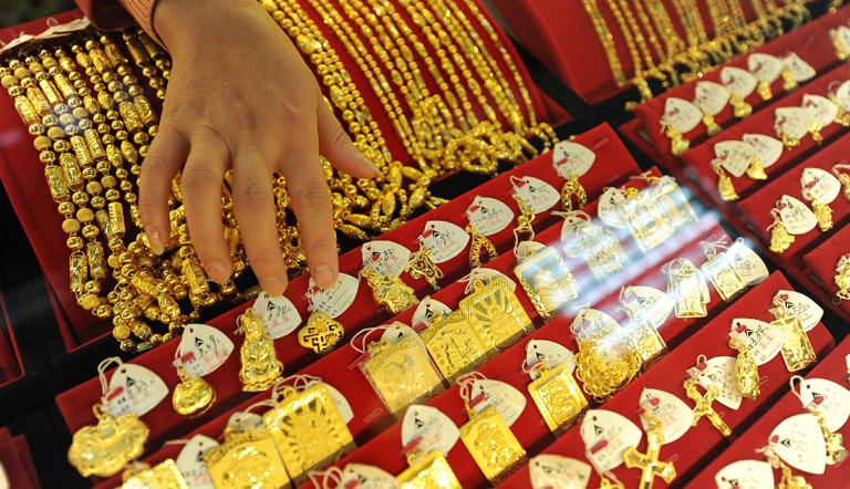 JOYERIA - A Chinese gold shop assistant shows off various gold jewellery at a shop in Hefei, east China