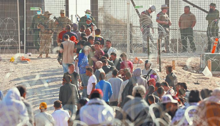 Migrants stand near the border wall after having crossed the U.S.-Mexico border to turn themselves in to U.S. Border Patrol agents, after the lifting of COVID-19 era Title 42 restrictions that have blocked migrants at the border from seeking asylum since 2020, as seen from Ciudad Juarez, Mexico May 12, 2023. REUTERS/Jose Luis Gonzalez
