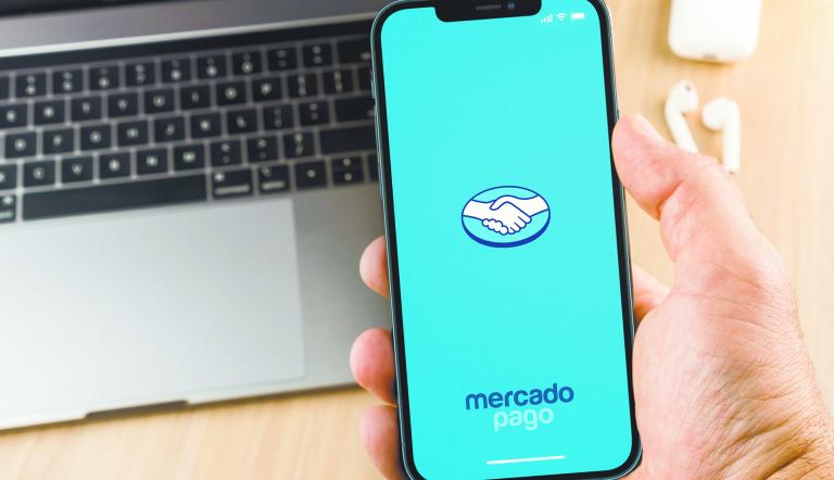 Male hand holding a smartphone with Mercado Pago app on the screen. Office environment. Rio de Janeiro, RJ, Brazil. January 2022.