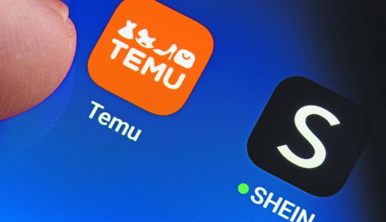 TEMU and SHEIN apps seen on the screen of smartphone and finger pointing at one of them. Temu app and Shein app are chinese budget shopping platforms. Stafford, United Kindom, May 2, 2023