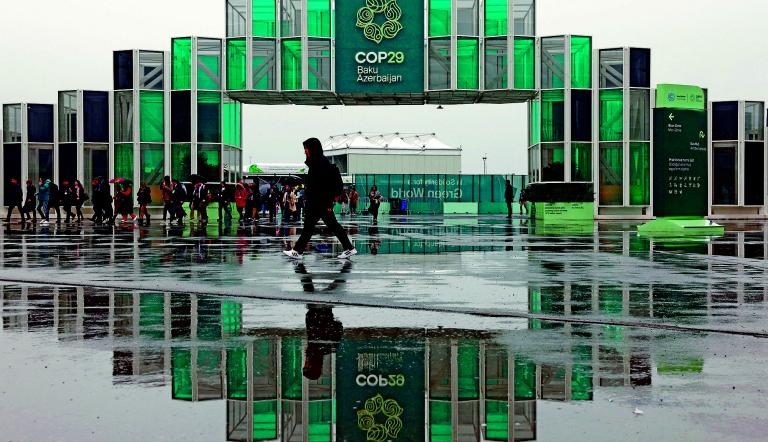 People walk at the entrance of the venue of the United Nations climate change conference COP29, in Baku, Azerbaijan November 18, 2024. REUTERS/Murad Sezer