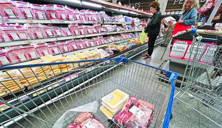 People buy groceries at a supermarket in Buenos Aires on September 19, 2024. (Photo by STRINGER / AFP)