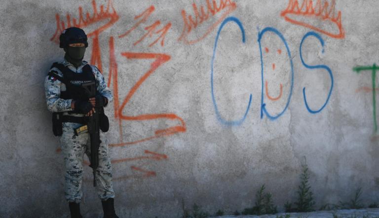 Un soldado mexicano hace guardia junto a unos grafitis del narcotraficante Mayo Zambada y el grupo criminal Cártel de Sinaloa (CDS), en Palmas Altas, municipio de Jerez de García Salinas, en Zacatecas.