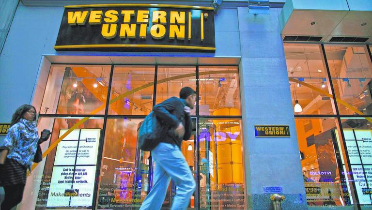 People walk past a Western Union branch at Times Square in New York