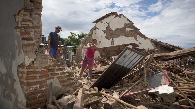 A woman removes debris from the remains of her home, which was destroyed in Thursday's magnitude 8.1 earthquake, in Union Hidalgo, Oaxaca state, Mexico, Sunday, Sept. 10, 2017. Mexico's government is distributing food to jittery survivors of an earthquake while residents have continued to sleep outside, fearful of more collapses and aftershocks. (AP Photo/Rebecca Blackwell)