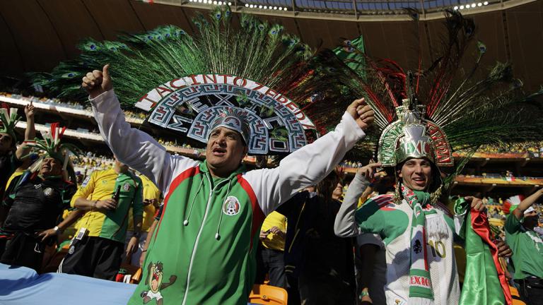 Mexican fans wearing Aztec styled headgears cheer during the opening ceremony before the 2010 World Cup opening match at Soccer City stadium in Johannesburg - Mexican fans wearing Aztec styled headgears cheer during the opening ceremony before the 2010 World Cup opening match between Mexico and South Africa at Soccer City stadium in Johannesburg June 11, 2010.         REUTERS/Kai Pfaffenbach (SOUTH AFRICA  - Tags: SPORT SOCCER WORLD CUP)