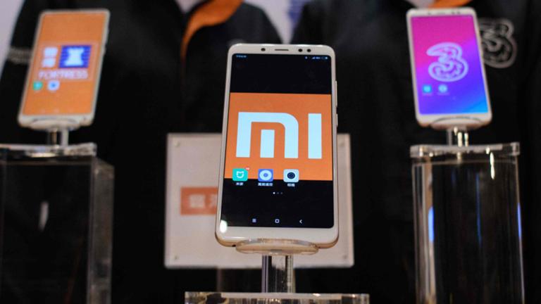 Mobile phones are displayed during a joint press conference by Xiaomi and CK Hutchison (CKHH) in Hong Kong on May 3, 2018.Chinese smartphone maker Xiaomi on May 3 kicked off what could be the world