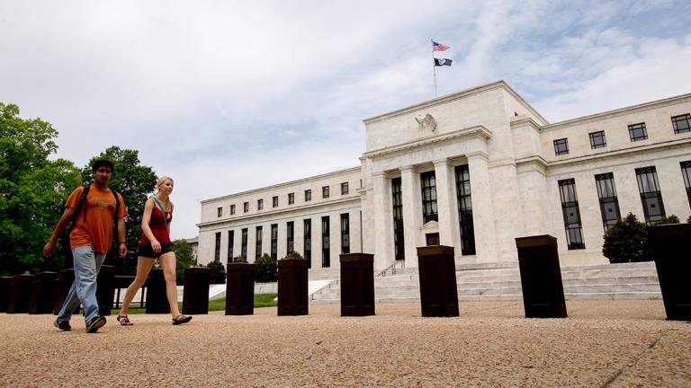 In this June 19, 2015 photo, people walk past the Marriner S. Eccles Federal Reserve Board Building in Washington. Federal Reserve policymakers have slightly lowered their projections for growth and inflation in the next two years, an outlook that likely factored into their decision to hold off on raising interest rates. (AP Photo/Andrew Harnik) - JUNE 19 2015 PHOTO