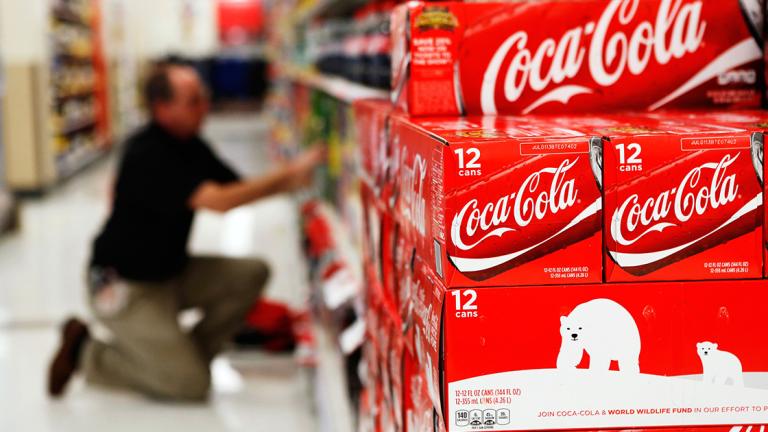 An employee arranges bottles of Coca-Cola at a store in Alexandria in this file photo - An employee arranges bottles of Coca-Cola at a store in Alexandria, Virginia October 16, 2012. Coca-Cola Co reported a slightly higher-than-expected profit February 10, 2015 as sales in North America, its biggest market, rose for the first time in four quarters, offsetting the impact of a stronger dollar on its overseas business. REUTERS/Kevin Lamarque/Files   (UNITED STATES - Tags: BUSINESS)