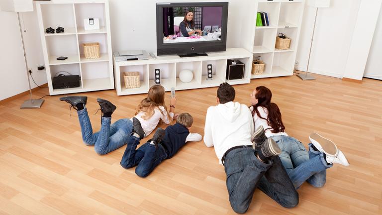 SHUTTERSTOCK - Familia joven que ve la televisi�n juntos en casa