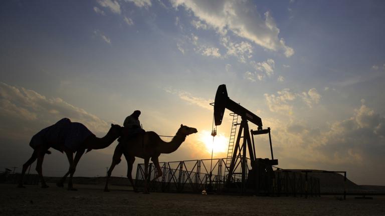 FILE- In this Sunday, Dec. 20, 2015 file photo, a man rides a camel through the desert oil field and winter camping area of Sakhir, Bahrain. OPEC nations have agreed in theory that they need to reduce their production to help boost global oil prices during a meeting in Algeria, but a major disagreement between regional rivals Saudi Arabia and Iran still may derail any cut. (AP Photo/Hasan Jamali, File) - FILE PHOTO