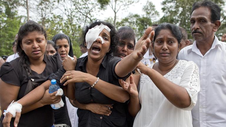 Anusha Kumari, center, weeps during a mass burial for her husband, two children and three siblings, all victims of Easter Sunday