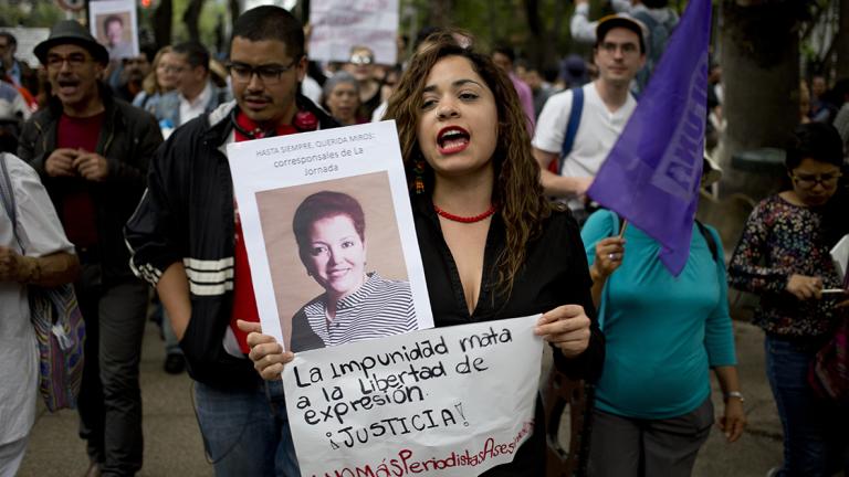 A woman shouts slogans holding a photo of Mexican journalist Miroslava Breach, gunned down in the northern state of Chihuahua on Thursday, and a sign that reads in Spanish: "the impunity kills freedom of speech, justice," during a demonstration in Mexico City, Saturday, March 25, 2017. Breach was the third journalist to be killed this month in one of the most dangerous countries for media workers. (AP Photo/Eduardo Verdugo)