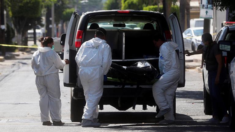 Forensic technicians place a body into a vehicle next to the site where others human remains were found in the municipality of Zapopan - REFILE - REMOVING RESTRICTIONS   Forensic technicians place a body into a vehicle next to the site where others human remains were found in the municipality of Zapopan, in Jalisco state, Mexico April 14, 2019. REUTERS/Fernando Carranza