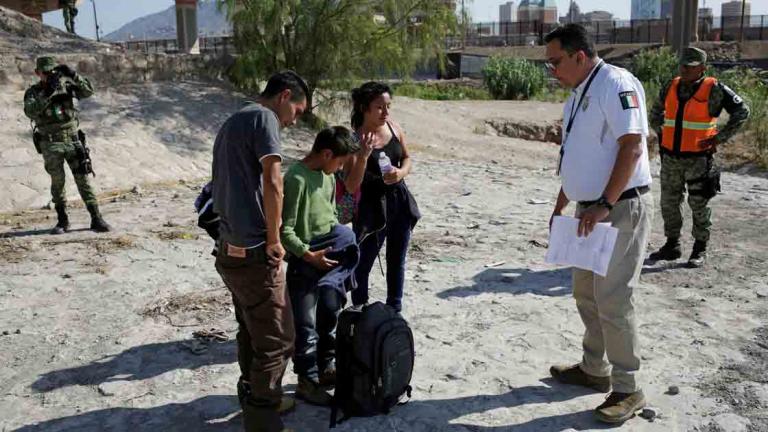 Un agente del Instituto Nacional de Migración habla con inmigrantes hondureños luego de que miembros de la Guardia Nacional Mexicana, en Ciudad Juárez, les impidieron cruzar la frontera hacia Estados Unidos. Foto: Reuters.