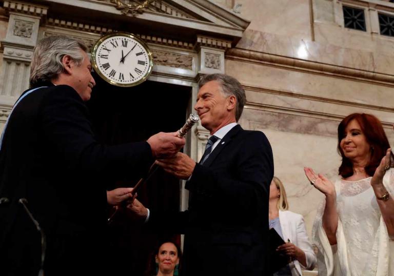 Alberto Fernández recibe el mando presidencial del saliente Mauricio Macri, acompañado de la expresidenta Cristina Fernández. Foto: AFP.