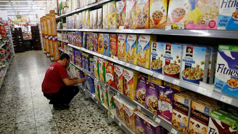 An employee arranges cereal boxes for sale at a supermarket in Jerusalem