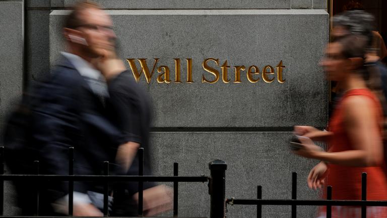 People walk on Wall St. outside the New York Stock Exchange (NYSE) in New York, U.S., August 7, 2019. REUTERS/Brendan McDermid