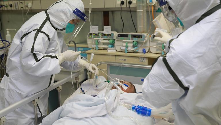 Medical staff in protective suits treat a patient with pneumonia caused by the new coronavirus at the Zhongnan Hospital of Wuhan University, in Wuhan