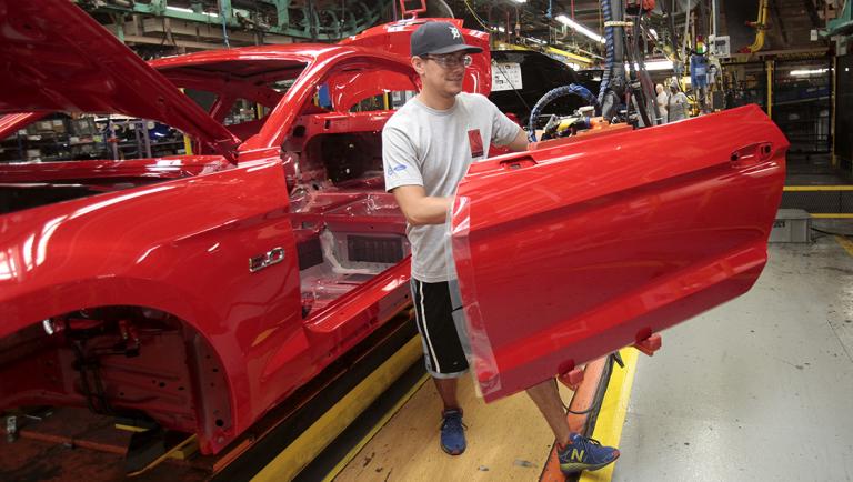 FILE PHOTO: A Ford Motor assembly worker works on a Ford Mustang vehicle at the Ford Motor Flat Rock Assembly Plant in Flat Rock, Michigan