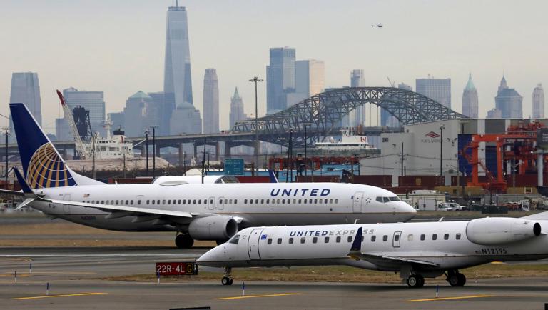 United Airlines passenger jets taxi with New York City as a backdrop