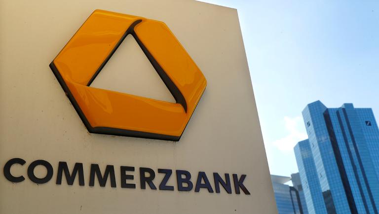 FILE PHOTO: A sign for an ATM of Commerzbank is seen next to the headquarters of Deutsche Bank (R) in Frankfurt