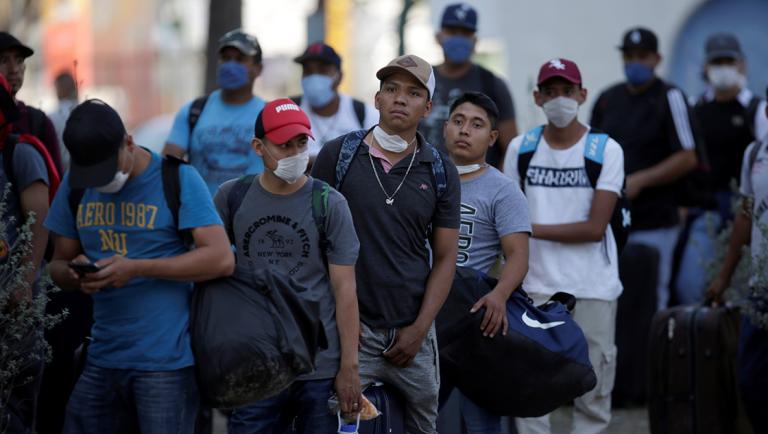 Migrants seeking for a U.S. work visa are pictured as they waiting to take a bus that will take to their hotel in Monterrey