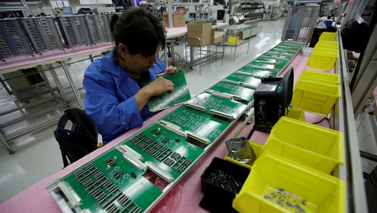 FILE PHOTO: Employee works on printed circuit board at the assembly line of a factory that exports to the U.S., in Ciudad Juarez