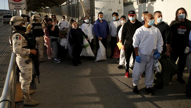 Mexican immigrants wait outside of a National Institute of Migration (INM) building after being deported from the United States and crossing the Paso del Norte border bridge amid the spread of the coronavirus disease (COVID-19), in Ciudad Juarez