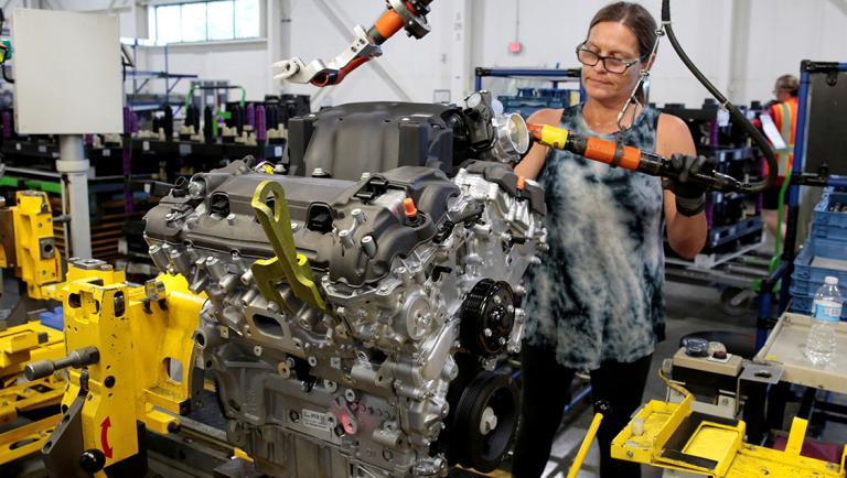 FILE PHOTO: A General Motors assembly worker works on assembling a V6 engine, used in a variety of GM cars, trucks and crossovers, at the GM Romulus Powertrain plant in Romulus,