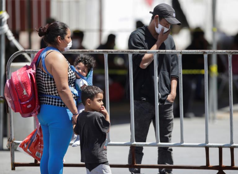 A migrant woman is seen with her children outside the migrant shelter Casa INDI, where some migrants have been infected by the coronavirus disease COVID-19, in Monterrey