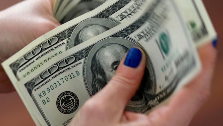 FILE PHOTO: A woman counts U.S. dollar bills at her home in Buenos Aires