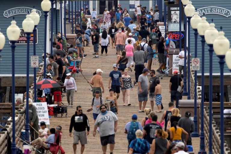 Hasta el 20 de julio había 311,000 muertes en las Américas por causa de la Covid-19. En la imagen, paseantes en California sin cubrebocas. Foto: Reuters.              