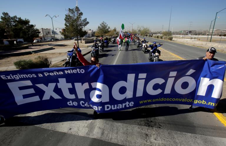 Personas sostienen una pancarta  para exigir al gobierno extradición del ex gobernador César Duarte, acusado de corrupción. Foto: Reuters