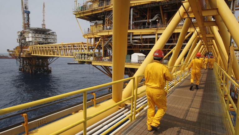 Employees walk on a bridge at the Mexico's state-run oil monopoly Pemex platform 