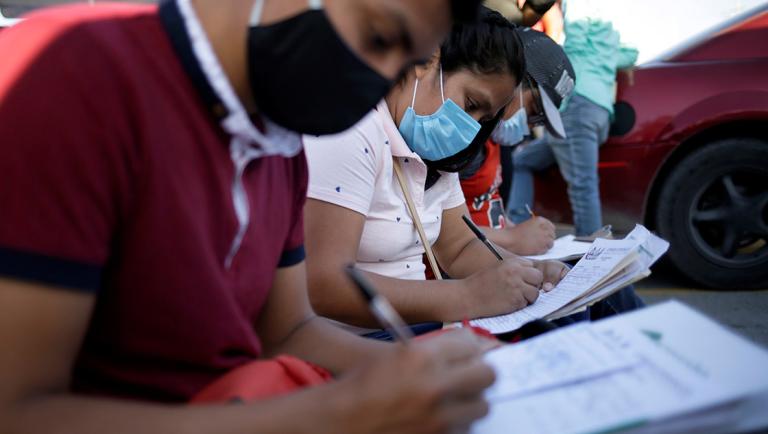 Job seekers fill out job application forms for assembly factories as the coronavirus disease (COVID-19) outbreak continues in Ciudad Juarez