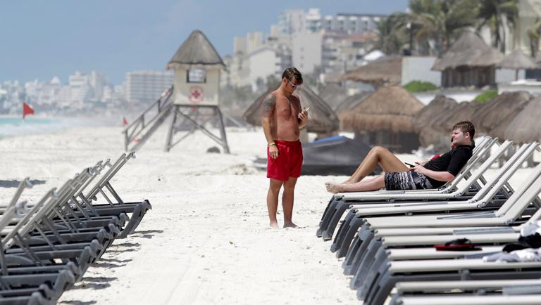 U.S. tourists relax at a beach after local authorities imposed strict sanitary measures to gradually reopen despite the coronavirus disease (COVID-19) pandemic, in Cancun, Mexico, June 11, 2020. Picture taken June 11, 2020. REUTERS/Jorge Delgado