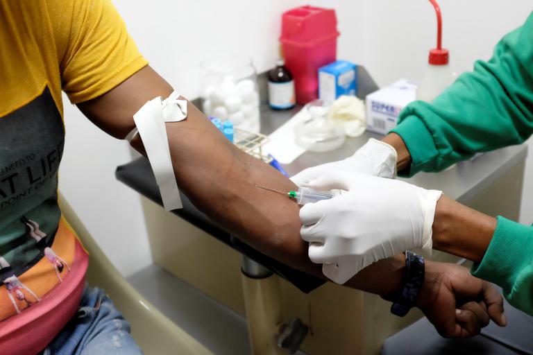 A nurse draws a blood sample for an HIV test at the lab of the NGO "Accion Solidaria" in Caracas