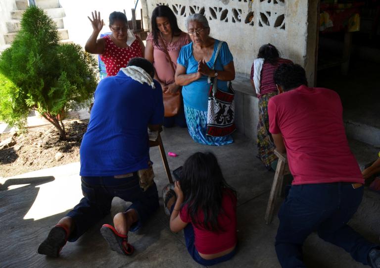 Amigos rezan en la casa de Gerardo Zacarías y su esposa María Victoria Orozco, quienes temen que su hija Paola Damaris esté entre los 19 cuerpos encontrados baleados y quemados en Camargo, Tamaulipas, en el norte de México. Foto: Reuters