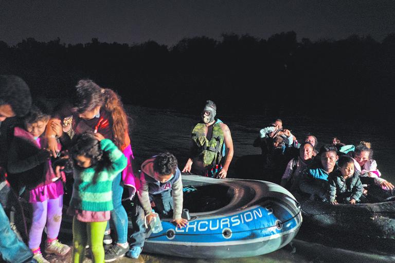 Migrants cross the Rio Grande river in Roma, TX