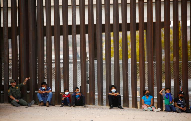 A U.S. Border Patrol agent plays rock-throwing with asylum-seeking migrants who crossed the Rio Bravo river to turn themselves to request for asylum in El Paso, Texas, U.S., as seen from Ciudad Juarez