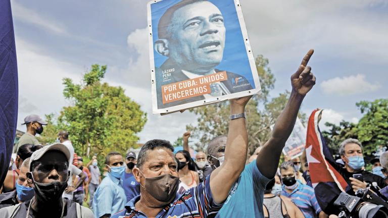 People shout slogans in support of the government as Cuba