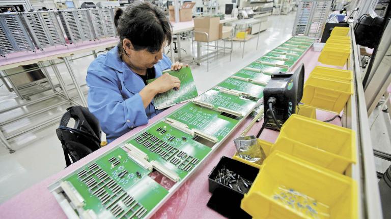 FILE PHOTO: Employee works on printed circuit board at the assembly line of a factory that exports to the U.S., in Ciudad Juarez